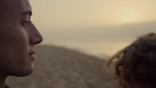 浪漫的情侣日落时在沙滩上亲吻视频的预览图