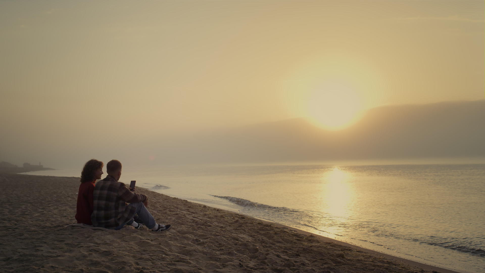 日落时分夫妻俩坐在沙滩上视频的预览图