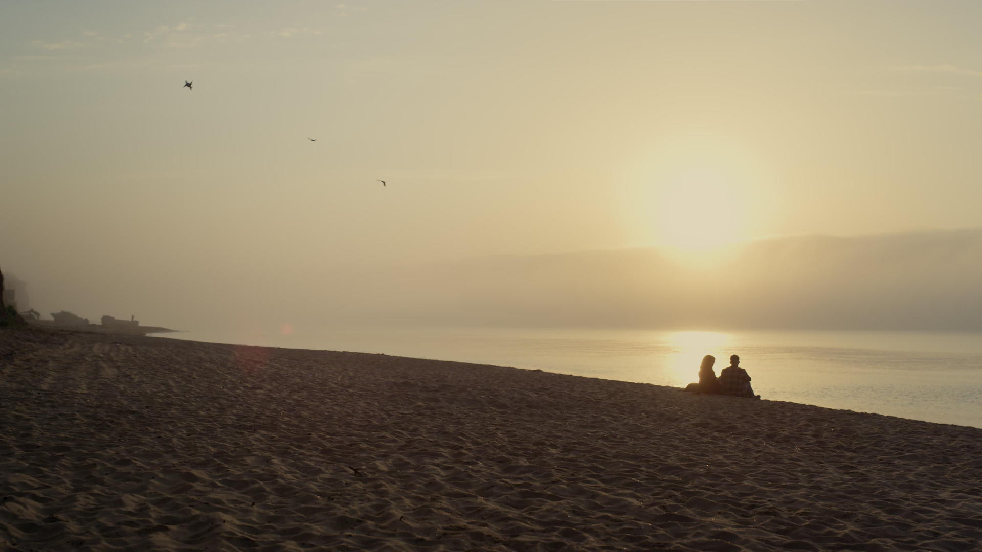 年轻夫妇在日落时分在沙滩上休息视频的预览图