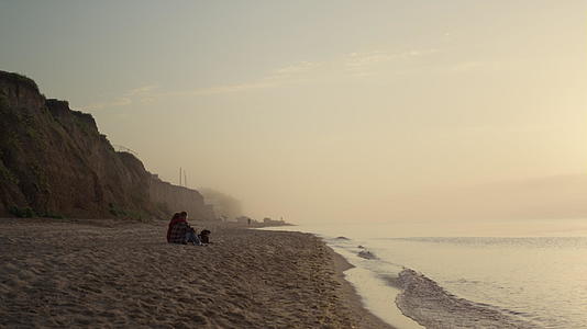 浪漫情侣日出时坐在海边视频的预览图