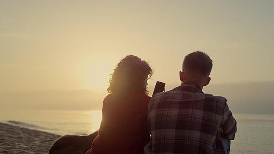 日出时夫妻俩一起在沙滩上放松视频的预览图