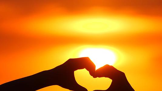 爱情标志或手势在日落阳光透过心在度假手工制作浪漫视频的预览图