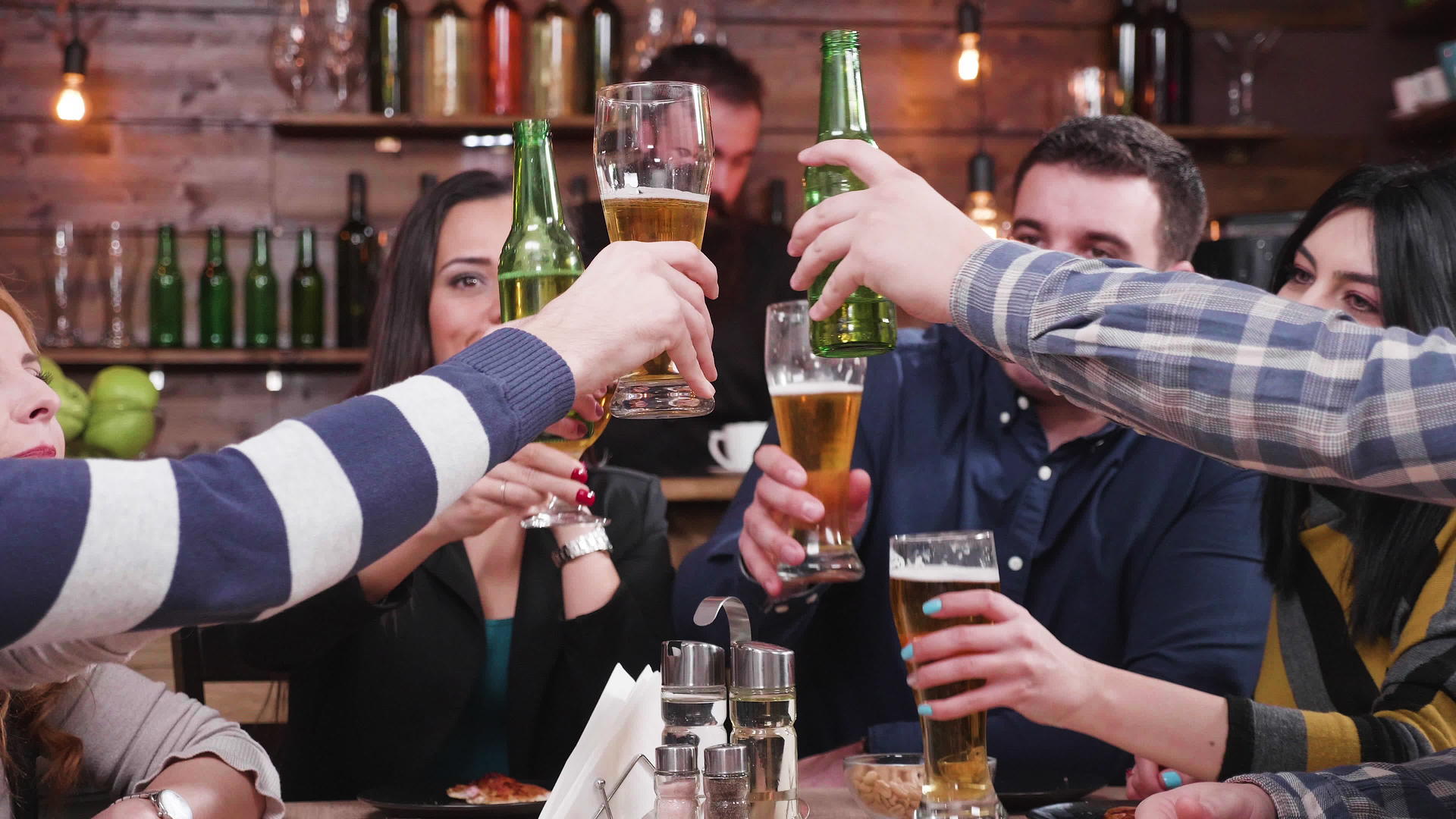 一群快乐的朋友微笑着把杯子和啤酒连在一起视频的预览图