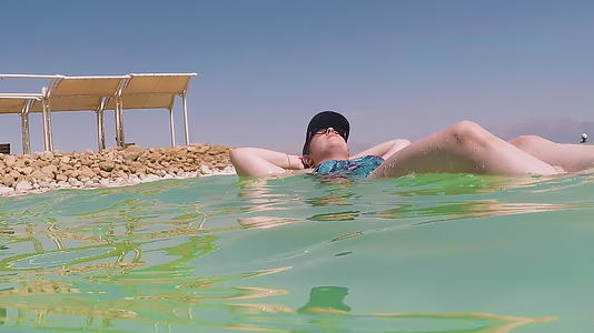 女游客漂浮在伊斯雷尔死海的盐水中视频的预览图