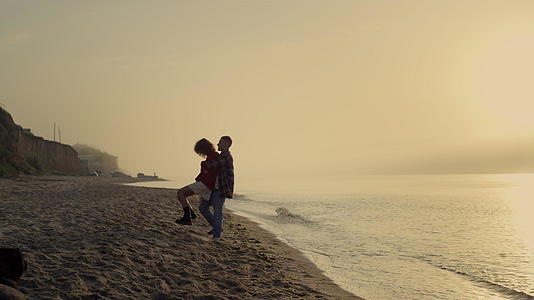 一对年轻夫妇在海边日出视频的预览图