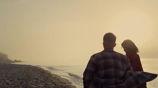 日出时在沙滩上奔跑的恩爱夫妇视频的预览图