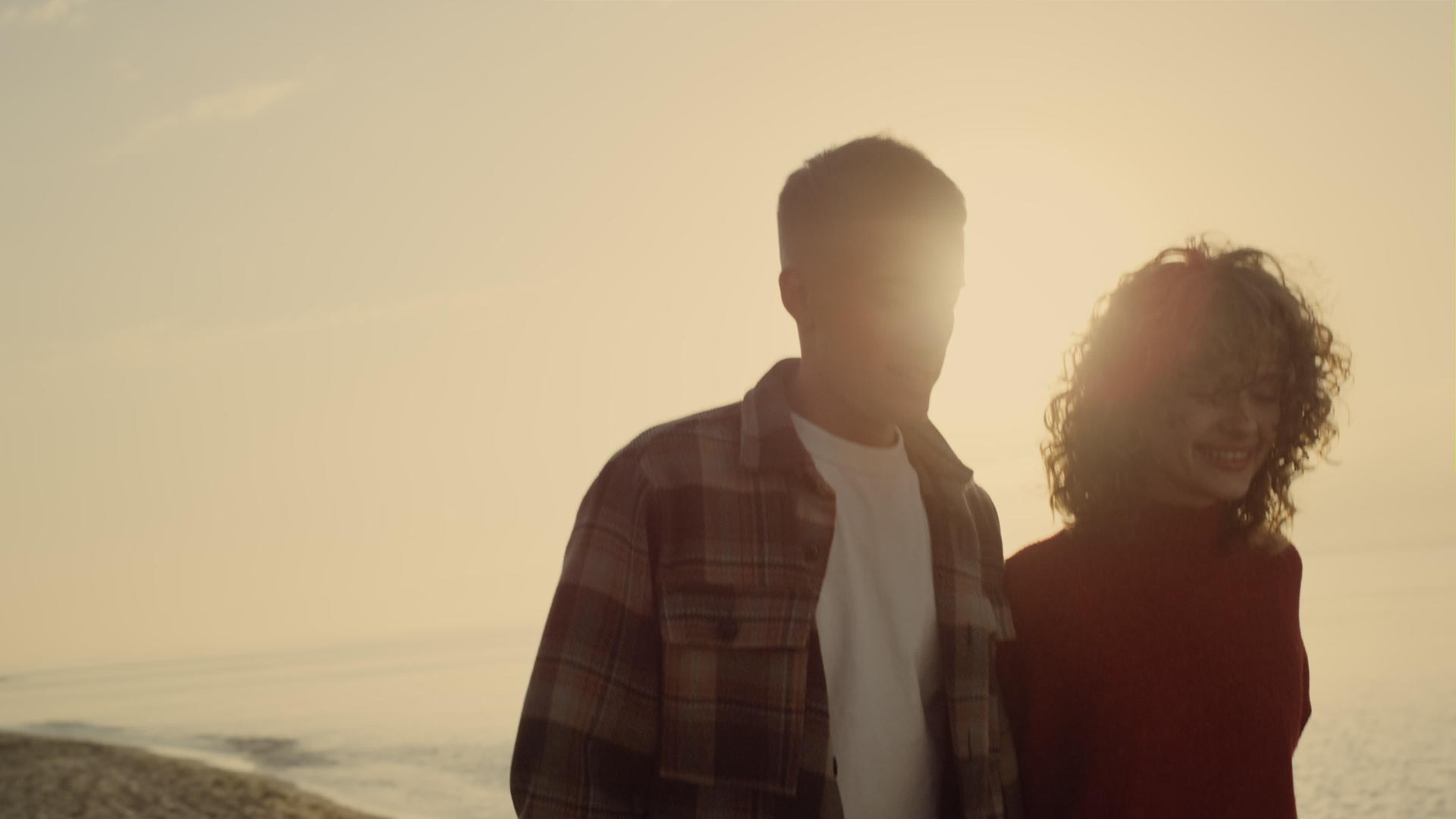 快乐的夫妇在日落时分在海边散步视频的预览图