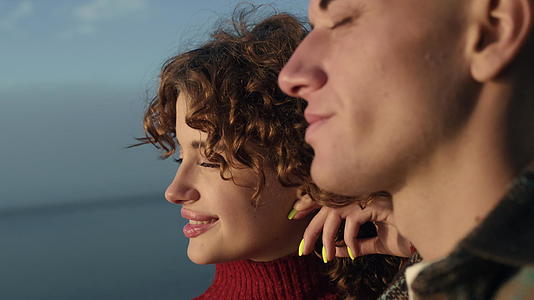 快乐的夫妇在日落时分在海边散步视频的预览图