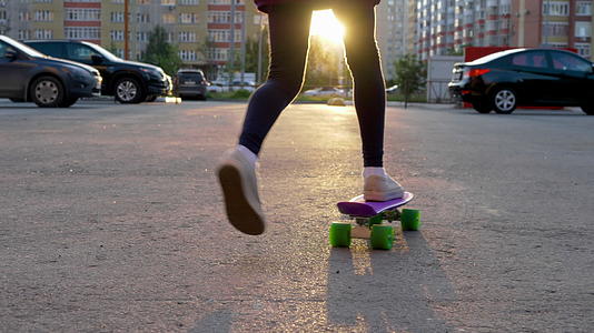 年轻女孩在市建筑的城市街道上玩滑板的年轻女孩视频的预览图