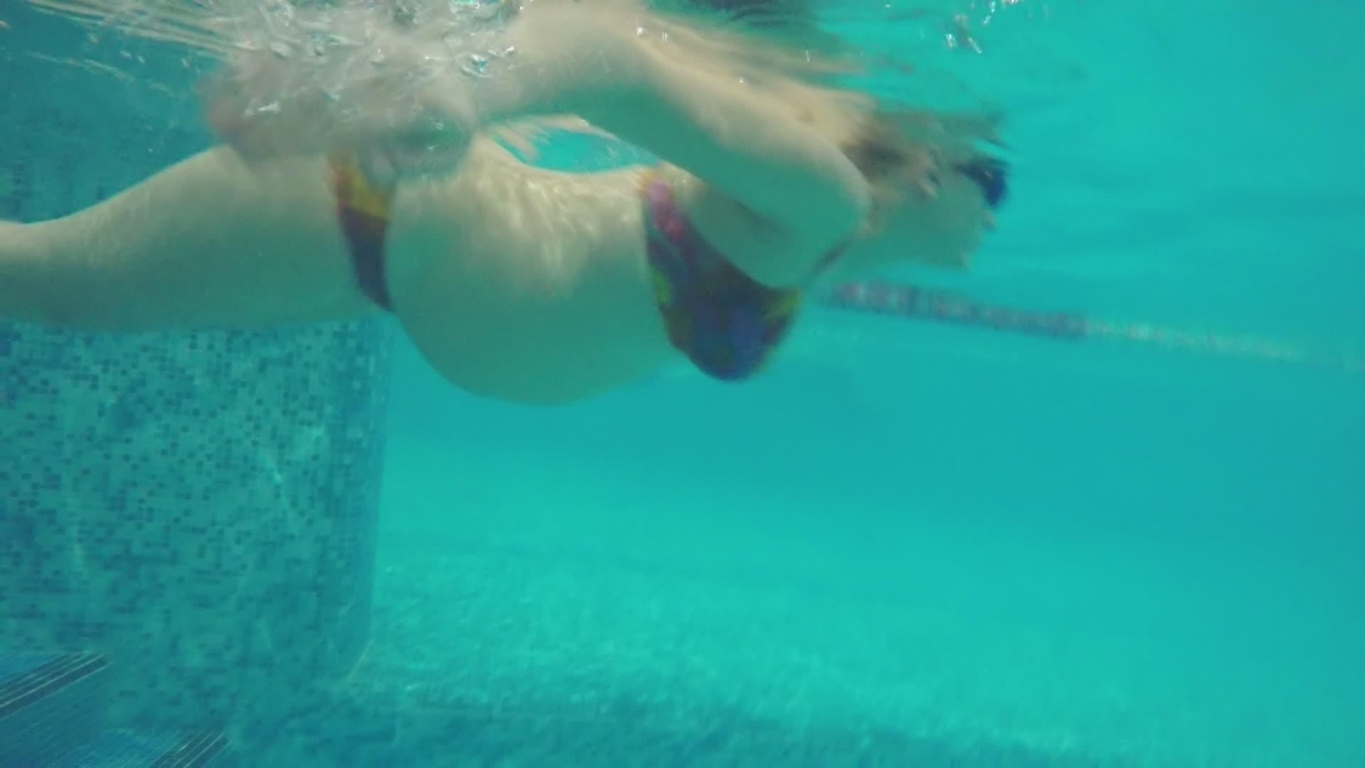 孕妇在游泳池游泳时的水下视图视频的预览图