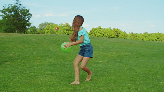 女孩在绿草地上打球视频的预览图