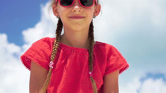 暑假期间海滩上可爱的小女孩的肖像视频的预览图