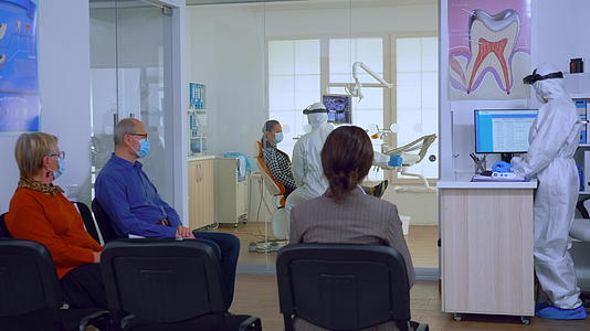 牙科诊所有保护性口罩的患者等待医生；在牙科诊所视频的预览图