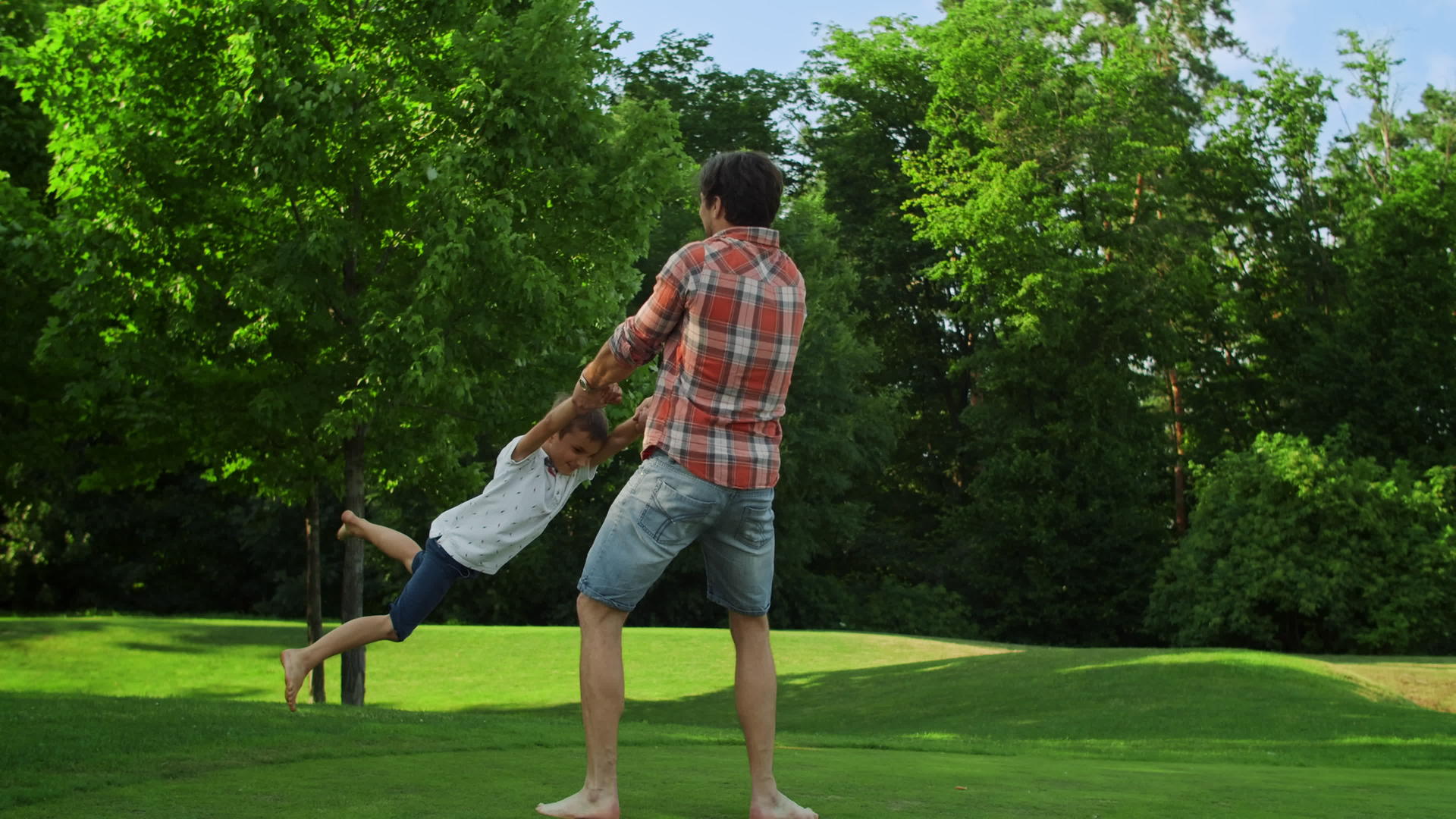 积极的男人和孩子在草地上玩耍视频的预览图