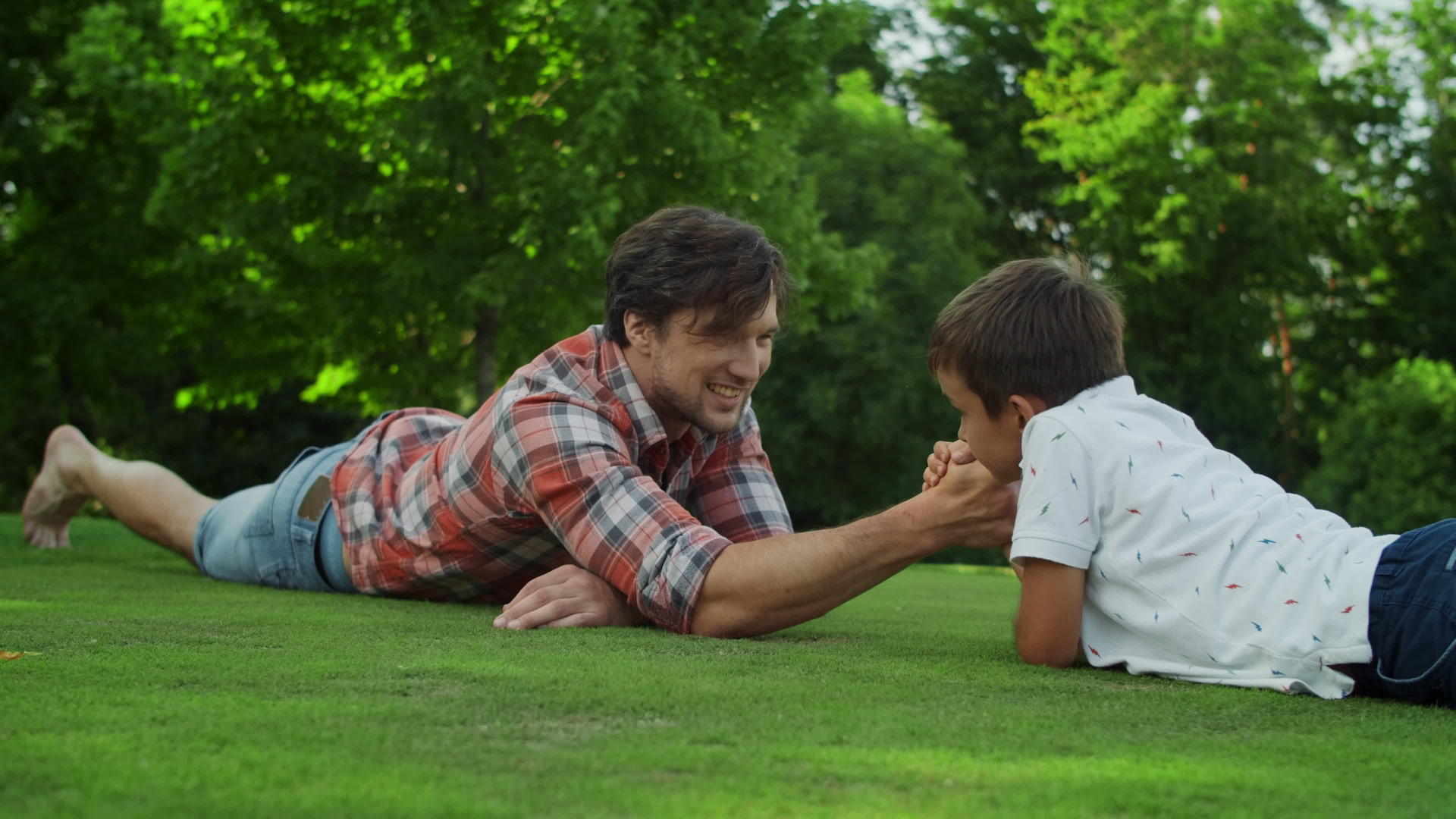 父亲和儿子躺在田野的草地上视频的预览图
