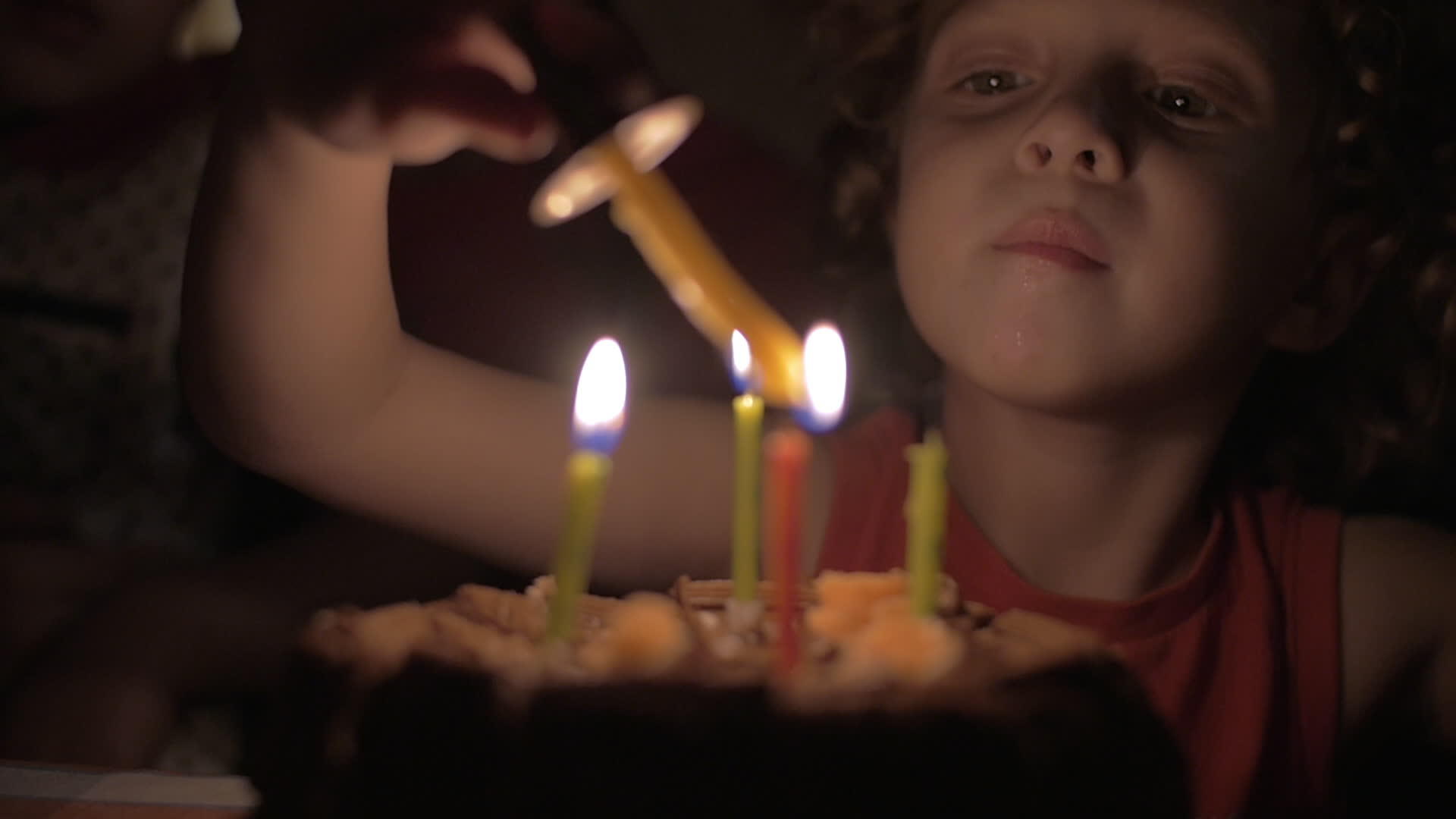 小女孩的慢动作视图在黑暗中点燃了生日蛋糕上的蜡烛视频的预览图