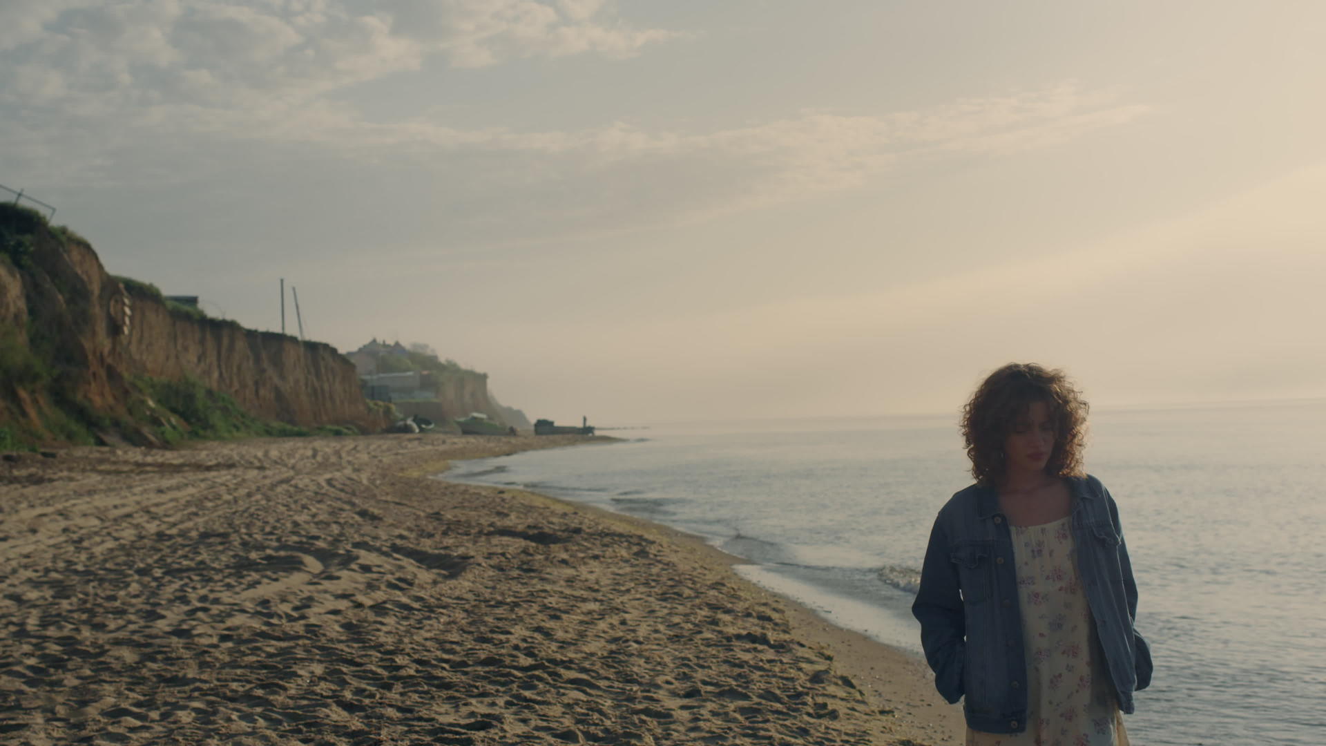 日落时分悲伤的女人沿着大洋彼岸行走视频的预览图