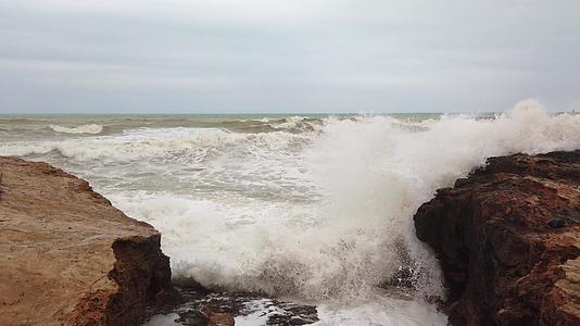 流过岩石表面的水和波浪产生白色泡沫视频的预览图