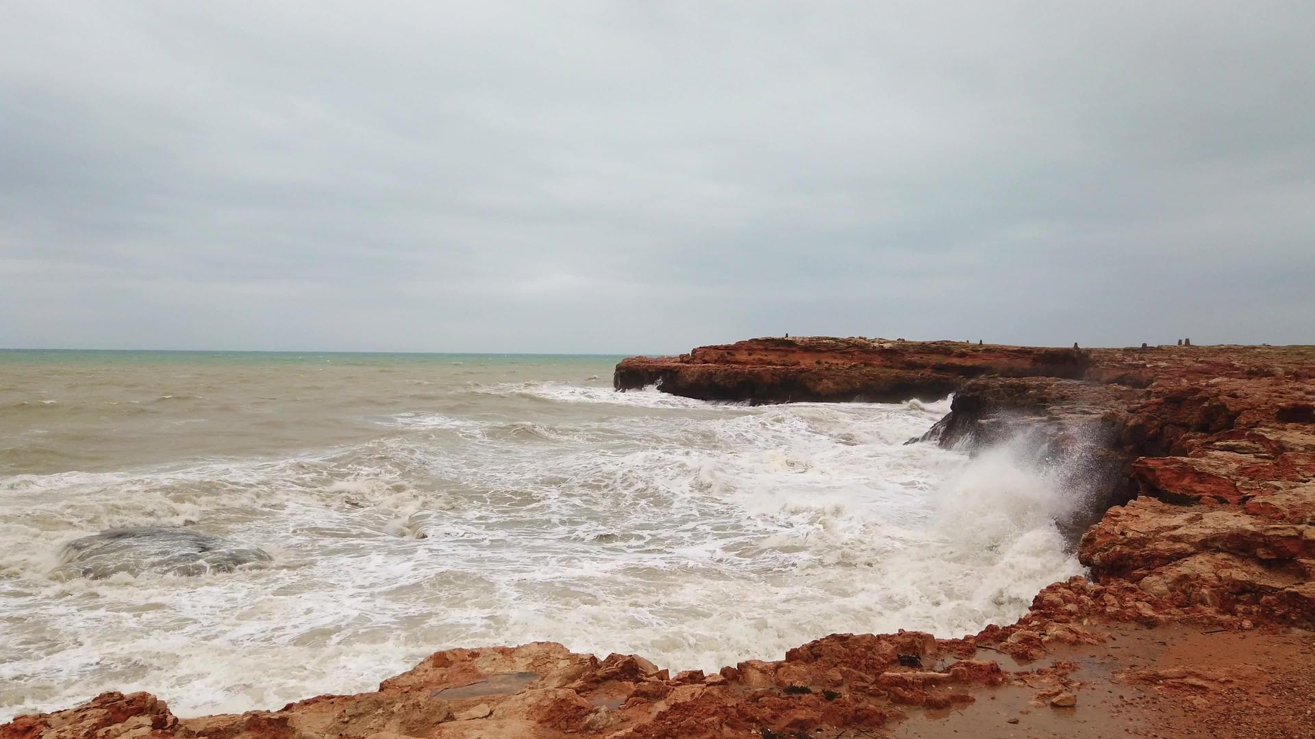 浪花溅在石头上风暴海和海浪撞击天空下的岩石4K视频的预览图