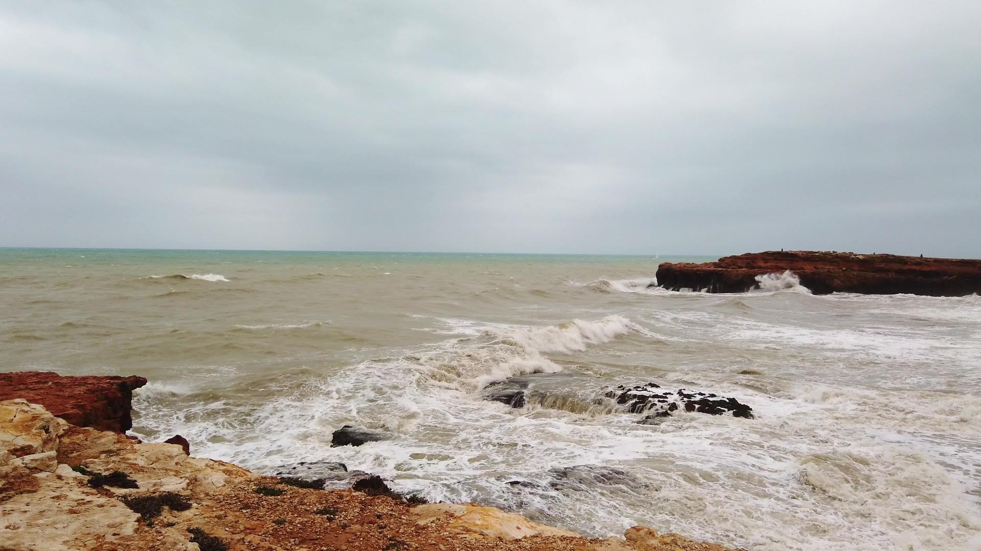 暴风雨前海浪冲进了一个岛屿的岩石悬崖视频的预览图