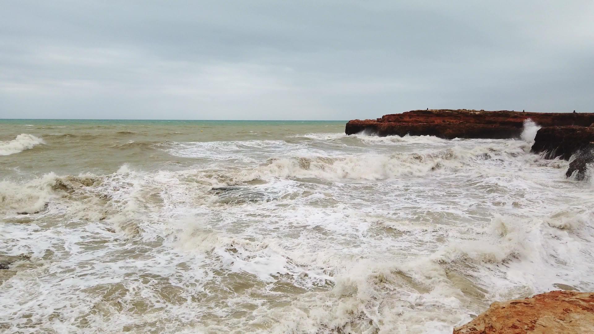 海浪在岩石海岸上破碎了白色泡沫视频的预览图