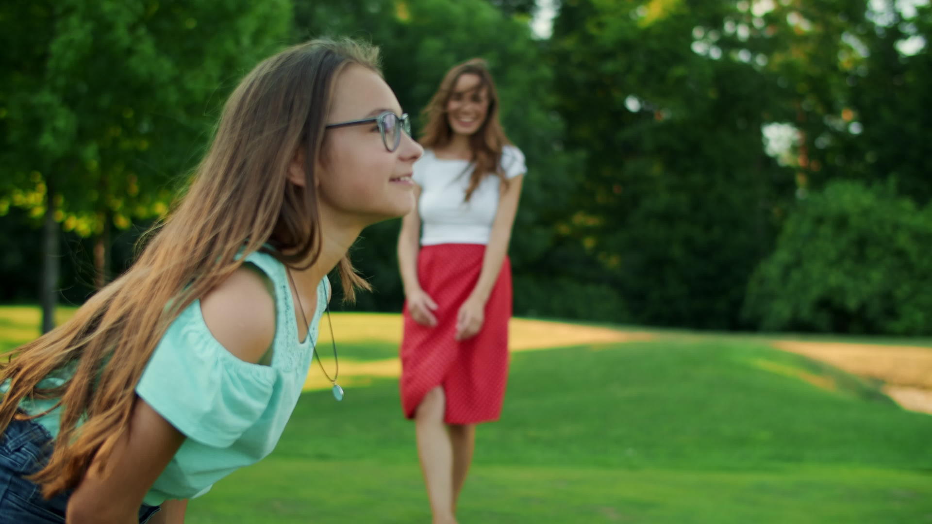 一个在公园里向女儿扔飞盘的女人视频的预览图