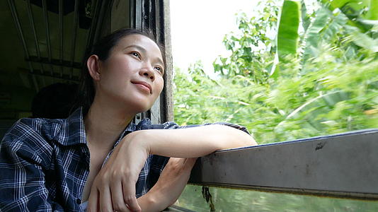 4K亚洲女人坐火车从曼谷的火车窗前往泰国视频的预览图