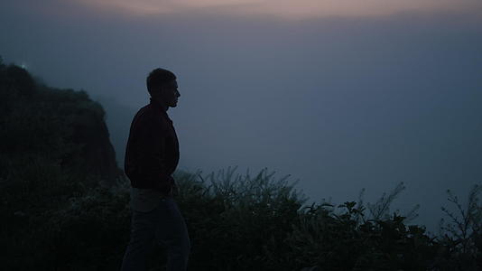 孤单的人在日出时走在山上视频的预览图