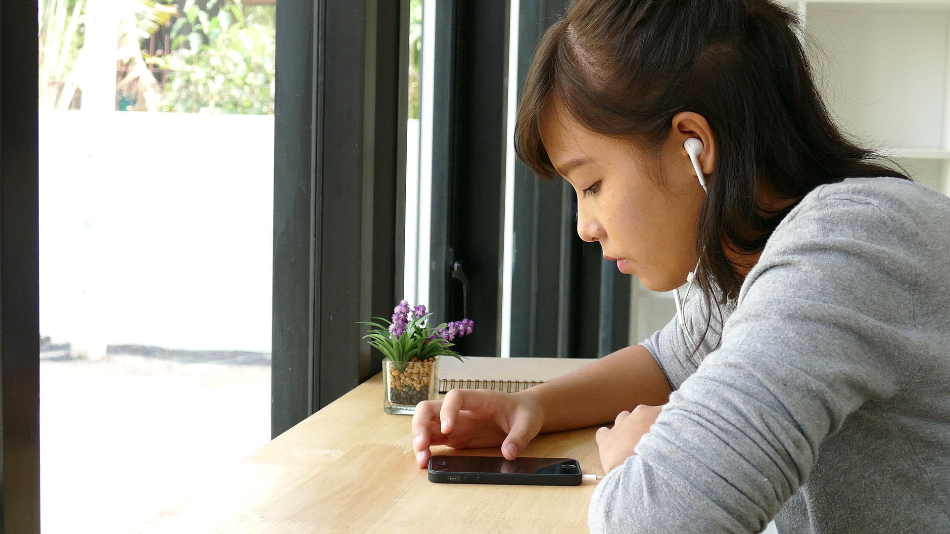 使用耳机佩戴耳机和在智能手机上听音乐的年轻女青年学生视频的预览图