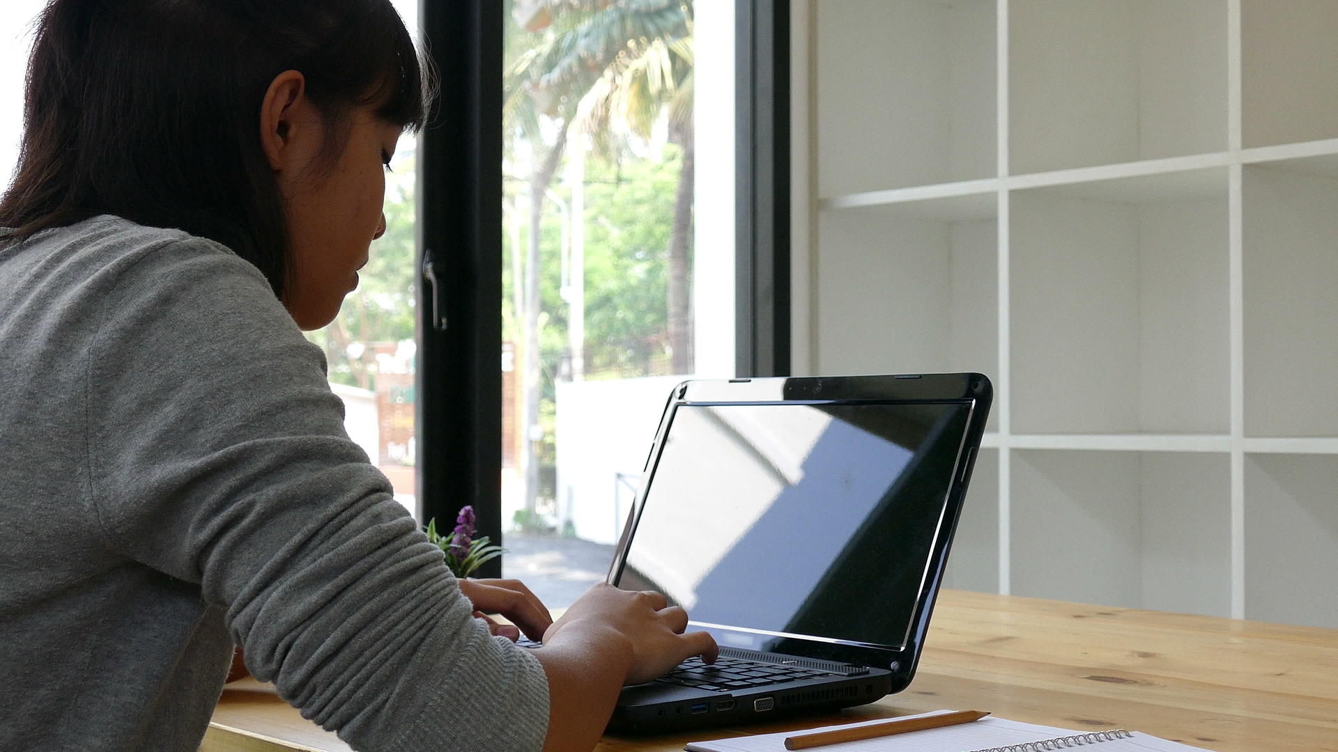 在学校学习的亚洲女青年学生在笔记本电脑上打字视频的预览图