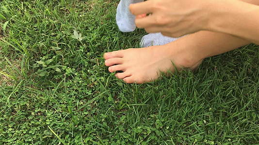 女人穿着绿草背景的袜子视频的预览图