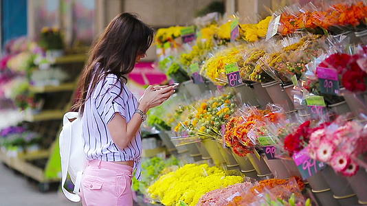 长发长发在欧洲市场采摘鲜花的年轻美女视频的预览图