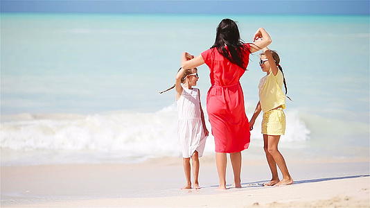 海滩上美丽的母亲和可爱的小女儿视频的预览图