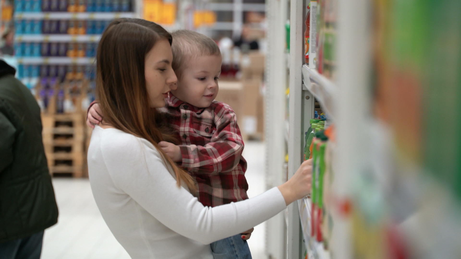 年轻的母亲和儿子在商店里买水或果汁视频的预览图
