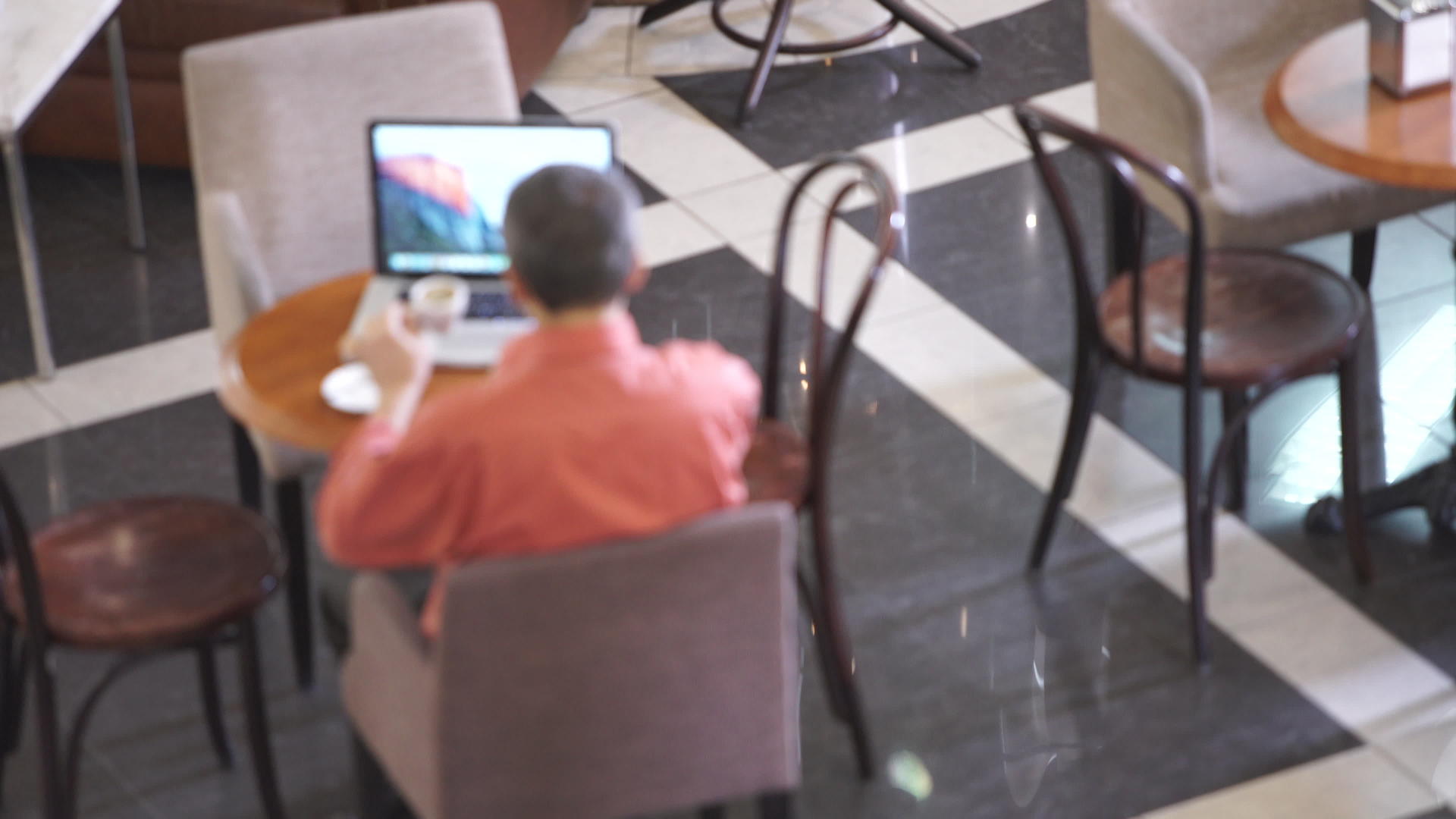 喝咖啡和工作的成年男子视频的预览图