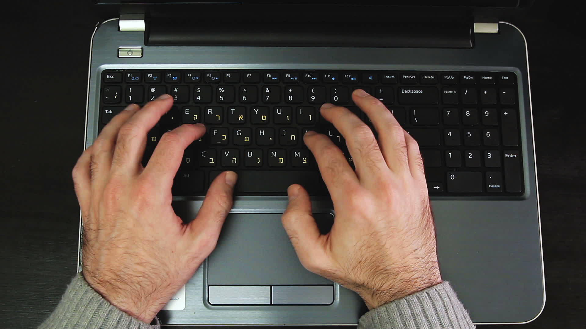 男人在键盘上打字的电影上写着Hebrew和英语字母视频的预览图