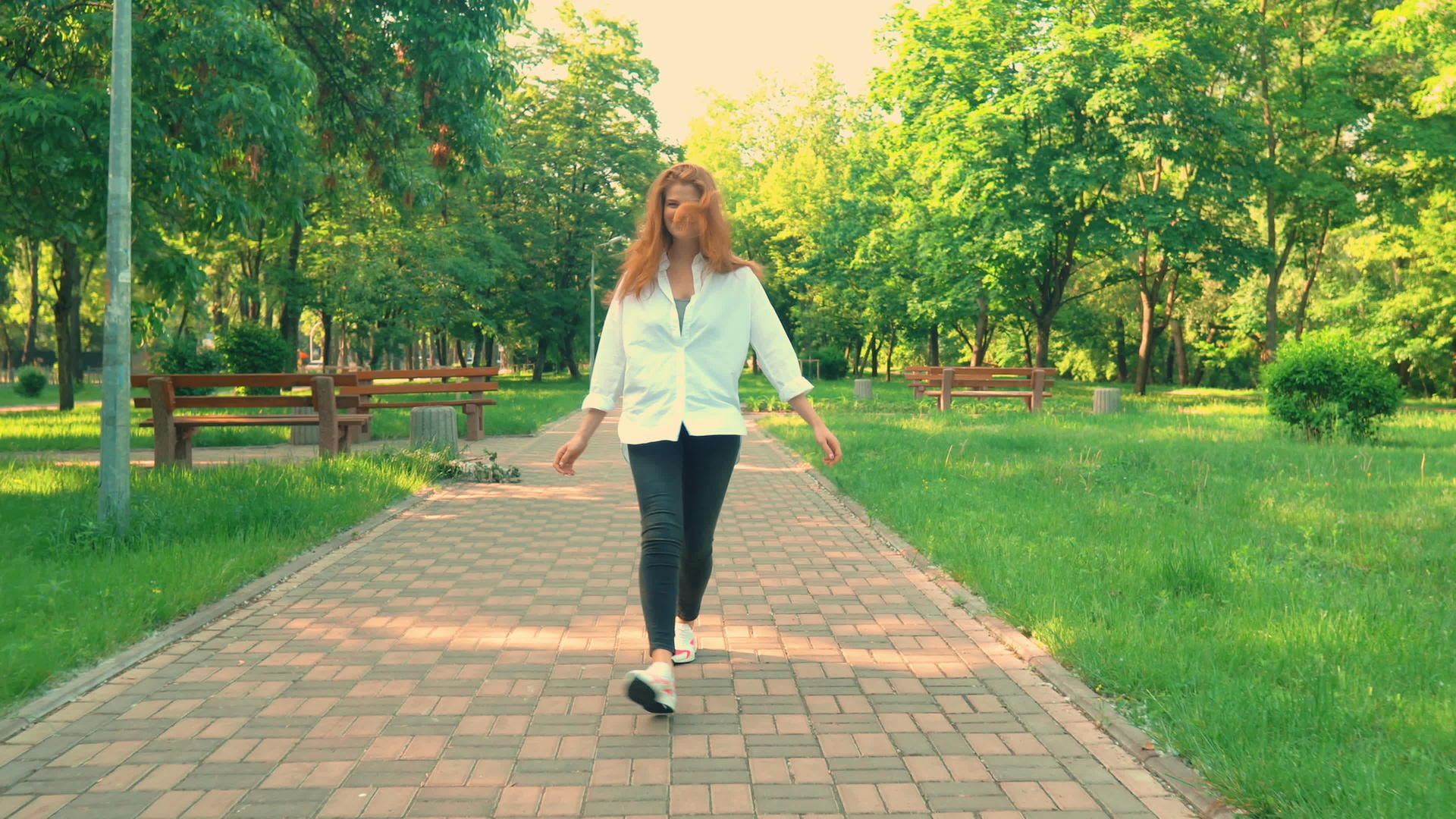 闲暇时间红发女孩在公园散步视频的预览图