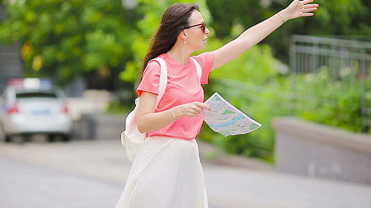 快乐的年轻女子带着地图走在欧洲城市的街道上视频的预览图