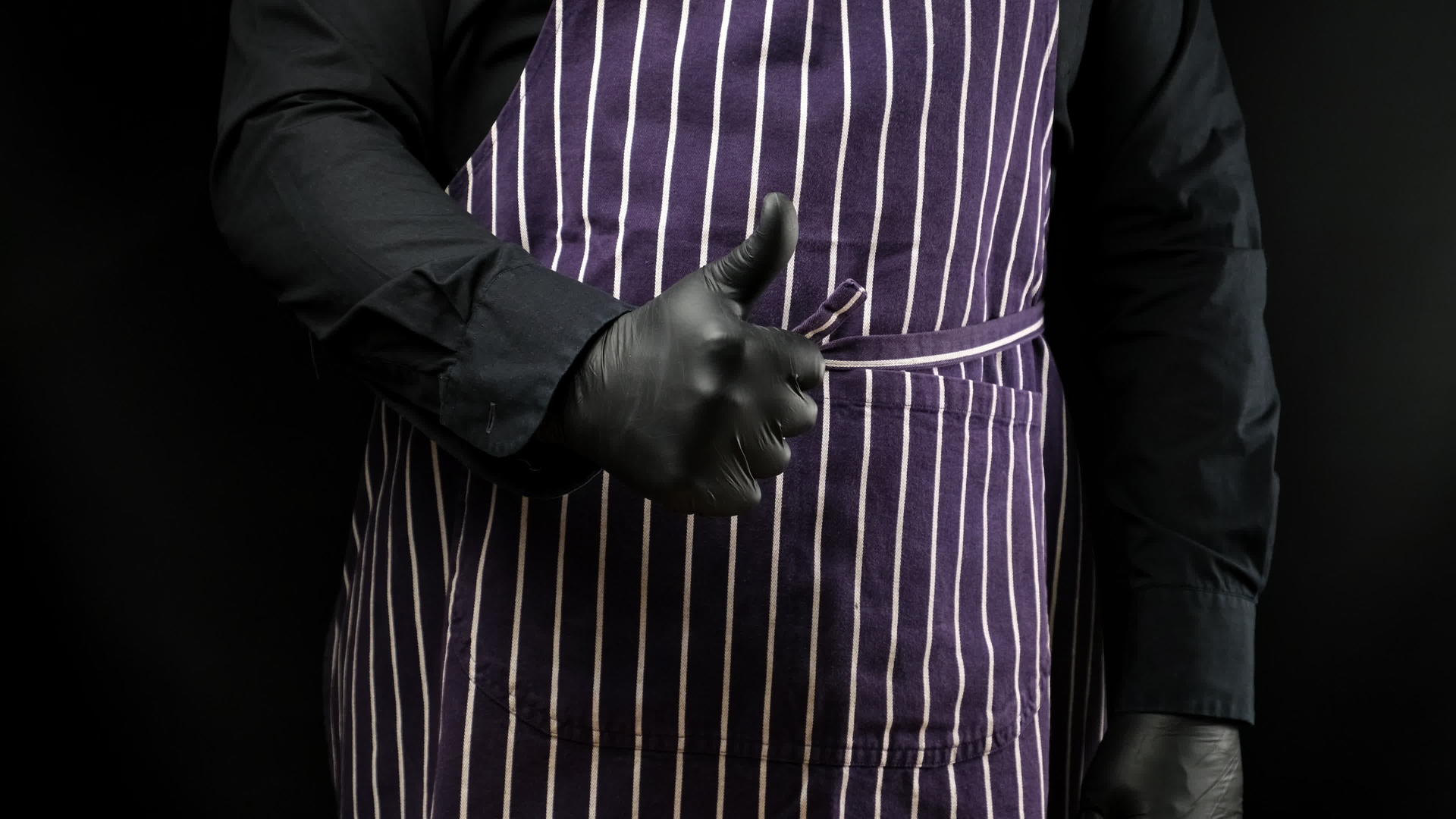 男性厨师穿着黑色制服和黑色乳胶手套表现出批准的手势视频的预览图