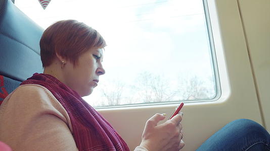 成年女性在乘车时使用手机视频的预览图