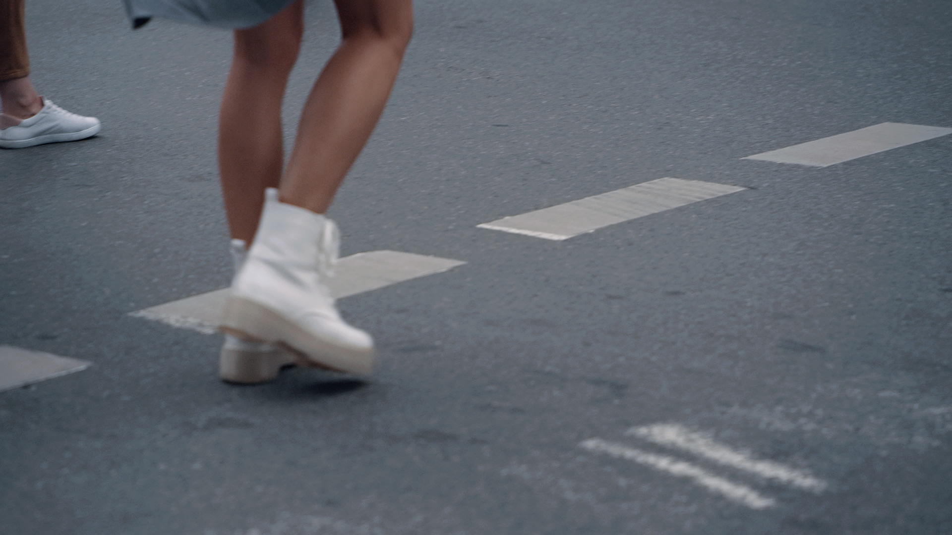 女人的腿在城市背景下人行横道上过马路视频的预览图
