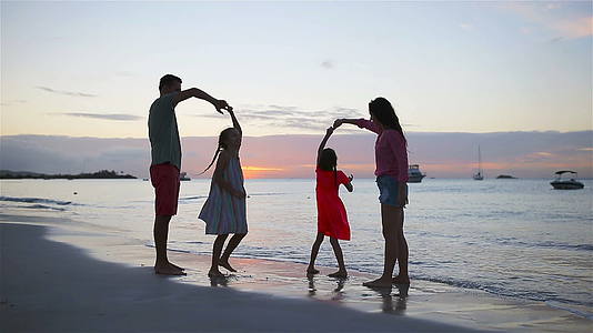 在白色的沙滩上丽的家庭晚上玩得开心视频的预览图