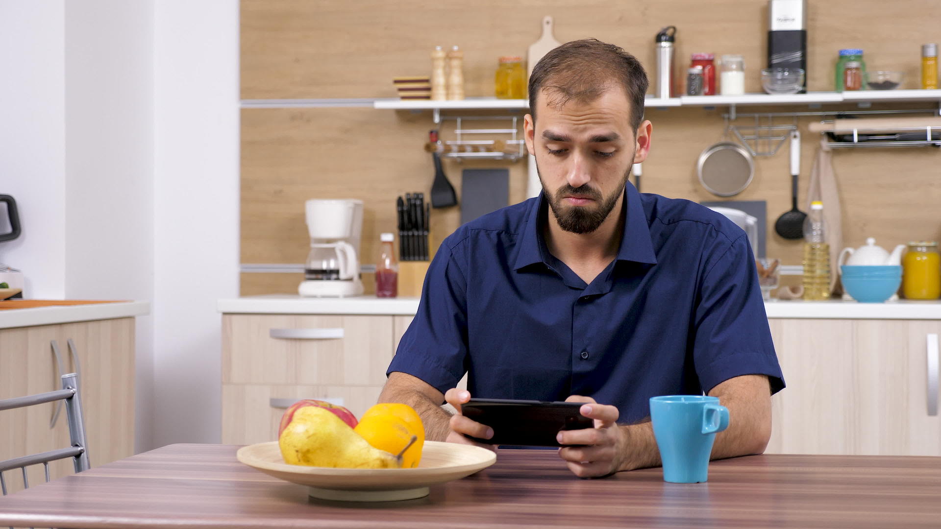 厨房里使用智能手机的人视频的预览图