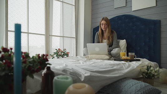 酒店早餐女孩用笔记本电脑工作视频的预览图