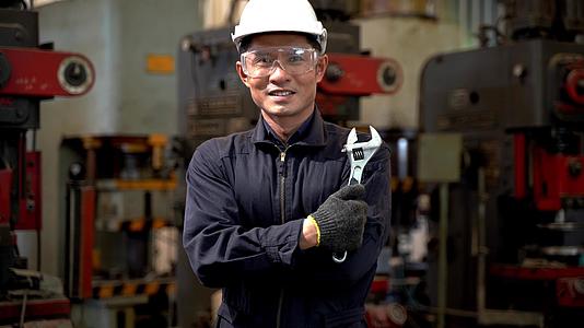 亚洲男工的体力劳动肖像自信地站着穿着深蓝色的工作服视频的预览图