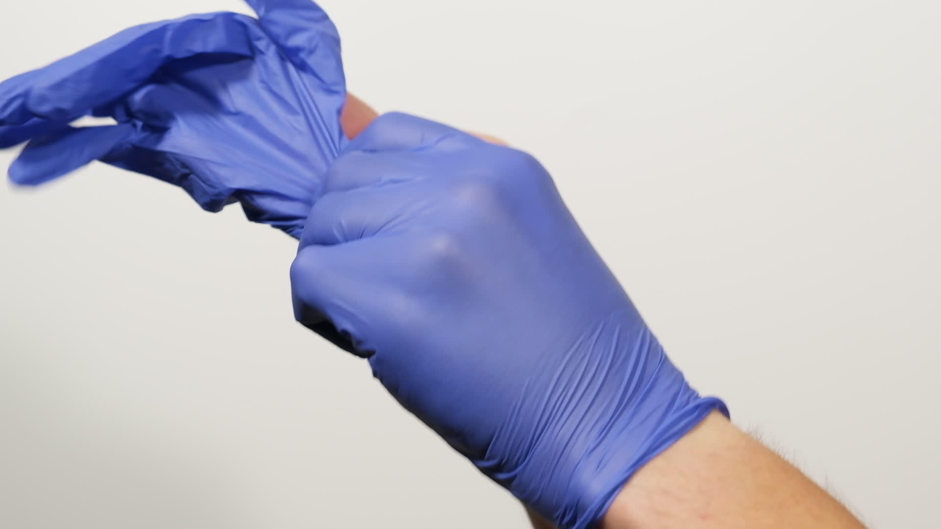 在流行和流行期间在手上戴上蓝色乳胶无菌手套的过程中视频的预览图