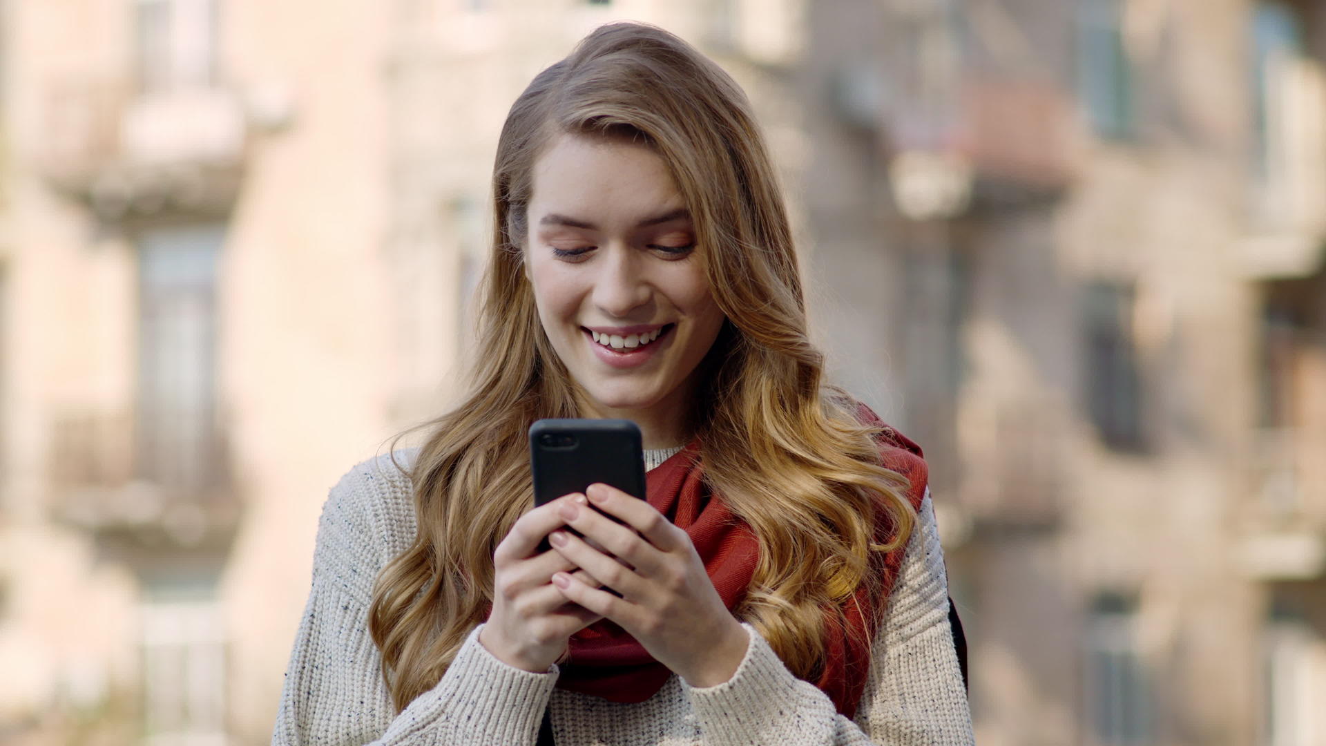 快乐的女人在户外通过电话发短信视频的预览图