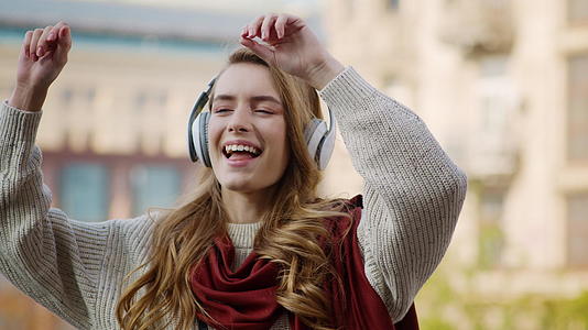 快乐的女士在外面的耳机上跳舞视频的预览图