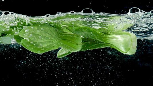 新鲜青菜掉入水中高速视频视频的预览图