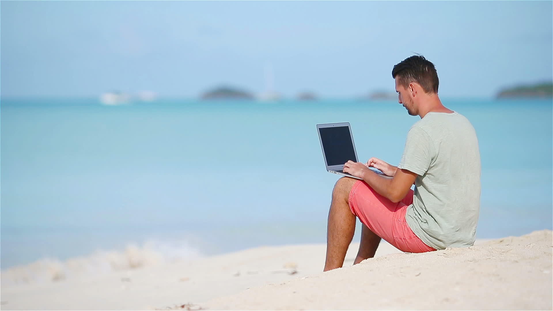 热带海滩上有笔记本电脑的年轻人视频的预览图